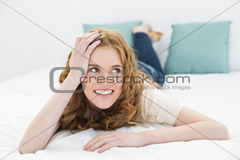 Smiling thoughtful pretty woman in bed
