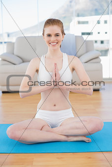 Toned woman in Namaste position at fitness studio