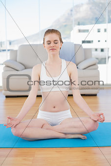 Toned woman in lotus pose at fitness studio