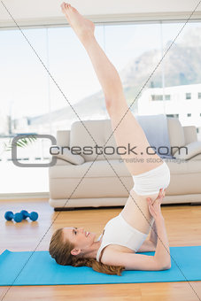 Sporty woman stretching body in fitness center