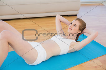 Sporty fit woman doing sit ups in fitness studio