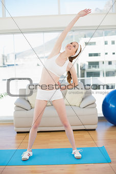 Sporty woman stretching body in fitness center