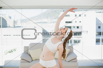 Sporty female stretching hand in fitness center