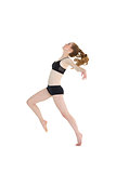 Full length side view of a sporty woman stretching