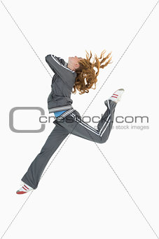 Full length side view of a sporty young blond jumping