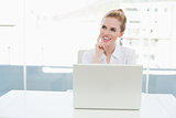Thoughtful businesswoman with laptop at office desk