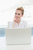 Thoughtful businesswoman with laptop in office