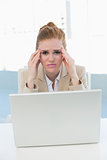 Businesswoman suffering from headache at office desk