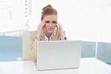 Businesswoman suffering from headache at office desk