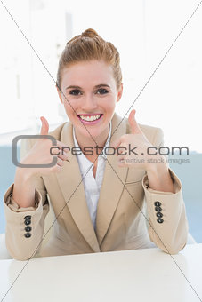 Elegant businesswoman gesturing thumbs up