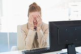 Worried businesswoman covering face at office