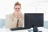 Worried businesswoman biting nails at desk in office