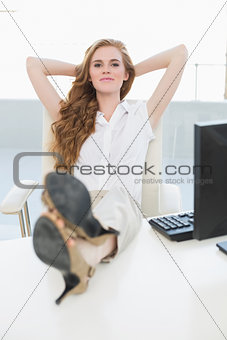 Relaxed businesswoman with legs on desk in office
