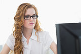 Serious businesswoman using computer in office