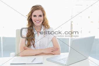 Smiling businesswoman with laptop in office