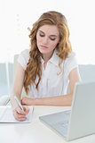 Businesswoman writing document at office
