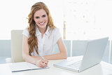 Smiling elegant businesswoman writing document at desk