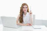 Beautiful businesswoman with laptop pointing upwards
