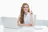 Beautiful businesswoman with laptop pointing upwards
