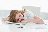 Tired businesswoman with head on laptop in office