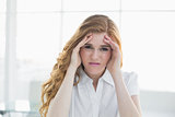 Elegant businesswoman suffering from headache in office