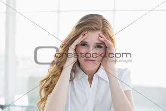 Elegant businesswoman suffering from headache in office