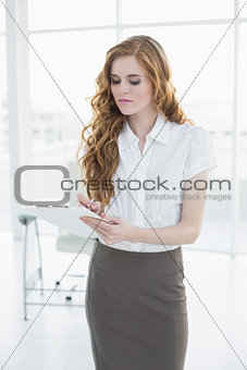 Elegant businesswoman writing notes in office