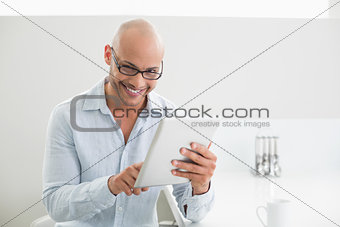 Casual smiling young man using digital tablet