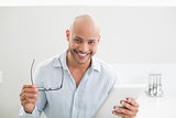 Casual smiling man using digital tablet at home