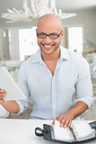 Casual smiling man with digital tablet and diary at home
