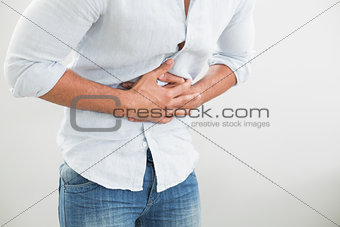 Mid section of man suffering from stomach pain