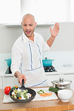 Man with vegetables in pan at the kitchen