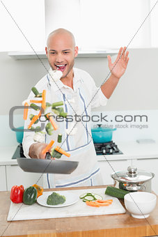 Man tossing vegetables at the kitchen