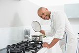 Smiling young man preparing food in kitchen