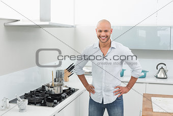 Portrait of smiling young man besides kitchen stove