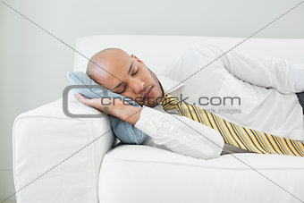 Businessman sleeping on sofa at home