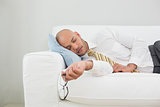 Businessman sleeping on sofa at home