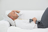 Businessman sleeping on sofa with digital tablet at home