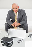 Smiling elegant businessman with laptop at home