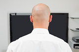 Close up rear view of a bald man using computer