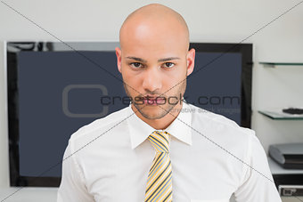 Portrait of a serious bald businessman at office