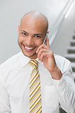 Smiling businessman using cellphone in office