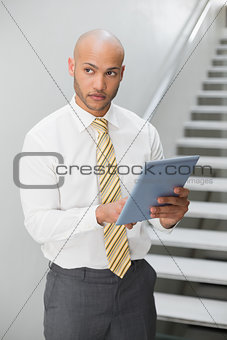 Businessman with digital tablet looking away