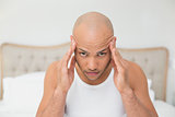 Close up of bald man suffering from headache in bed