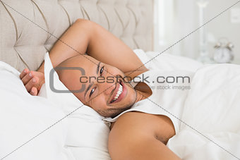 Portrait of smiling bald man resting in bed
