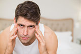 Close up of man suffering from headache in bed