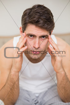 Close up of man suffering from headache in bed