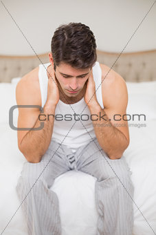 Thoughtful young man sitting in bed