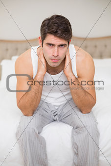 Portrait of a serious man sitting in bed