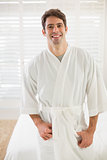 Portrait of smiling man in bathrobe in bedroom